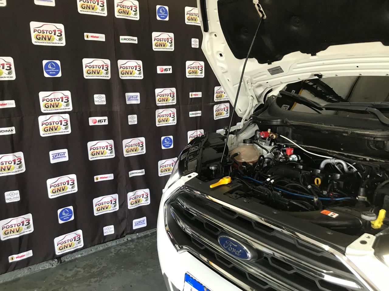 Instalação de sistema GNV - motor com capô aberto mostrando componentes do kit GNV